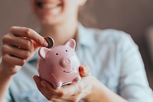 Patient inserting a coin into her piggy bank