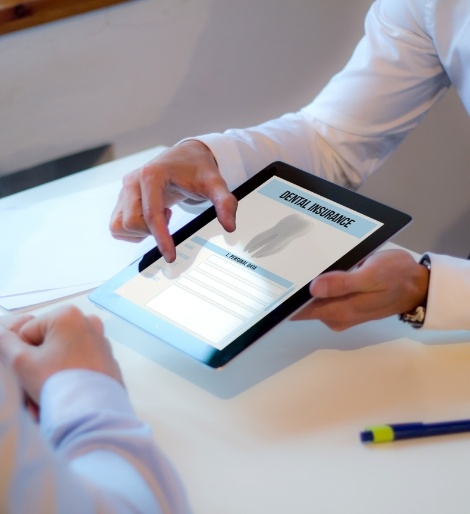 Two people looking at dental insurance form on a tablet