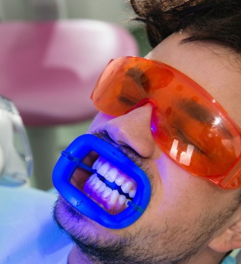 Man in dental chair getting his teeth professionally whitened