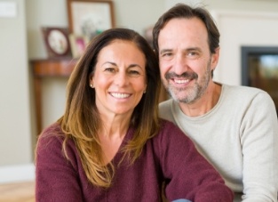 Older man and woman smiling together in their home