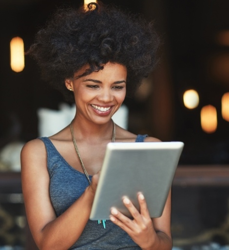 Woman smiling while scrolling on a tablet