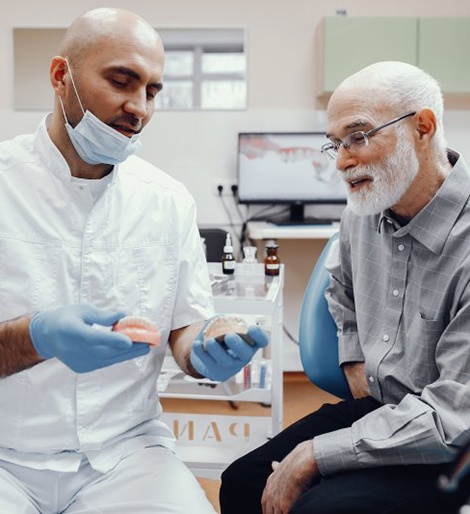 a dentist talking to a patient about implant dentures