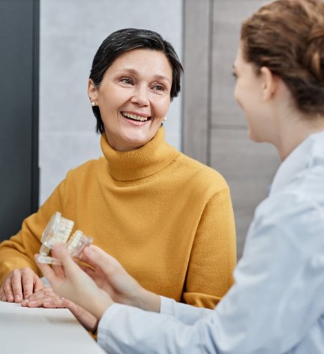 a patient smiling while talking to her implant dentist