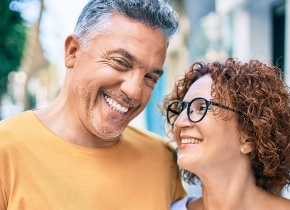 Man and woman smiling together on city sidewalk