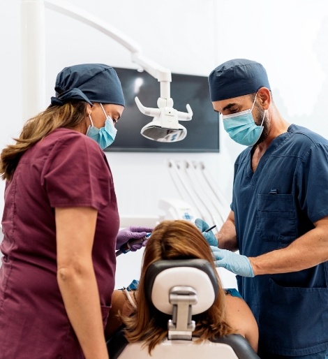 Dentist and assistant giving a patient a dental exam