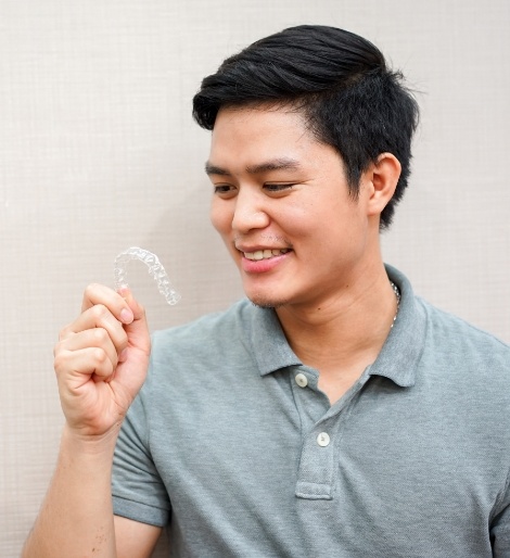 Young man holding a clear aligner