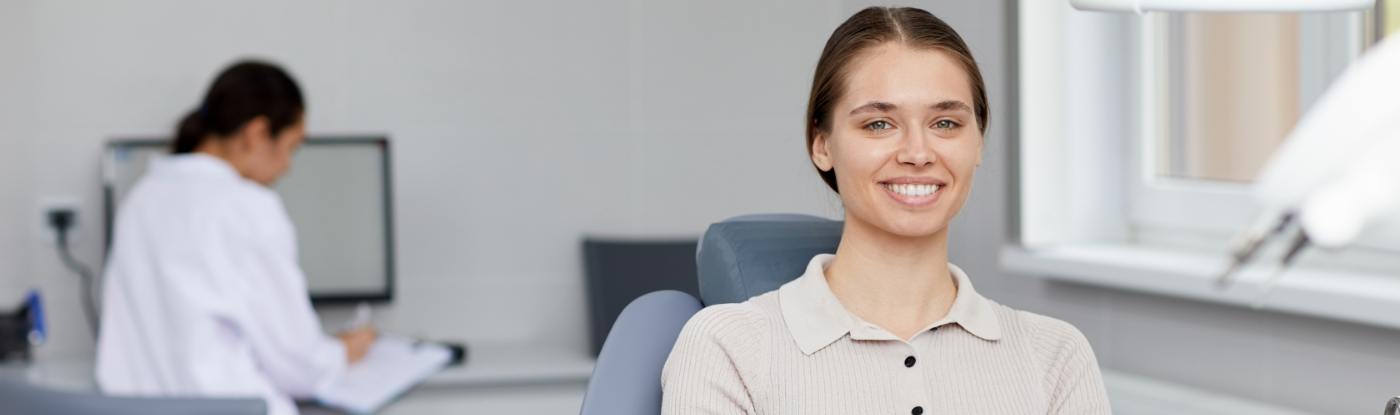 Woman smiling in dental chair with Allen dental team member in background