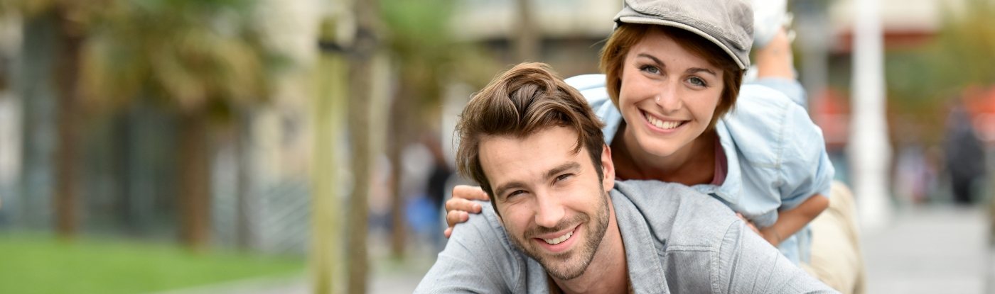 Young man and woman smiling outdoors together after preventive dentistry in Allen