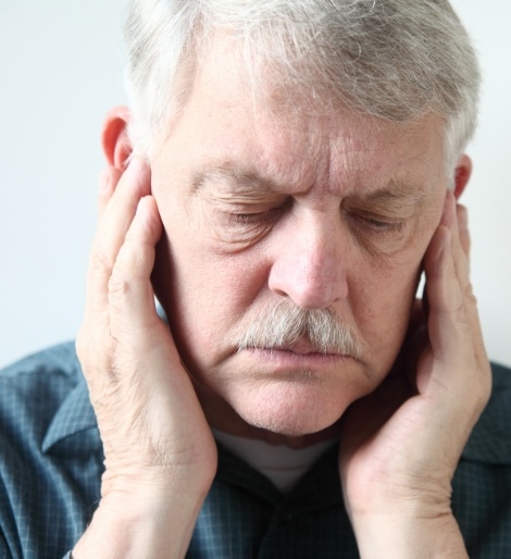 Senior man holding his temples in pain